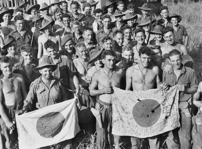 22nd September 1943. Australian Soldiers from the 2-6th Independent Company diplay Japanese flags they captured during the Battle of Kaiapit between 19 and 20 September 1943. Second Worl